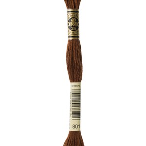 May include: A brown DMC embroidery floss with a label that reads "DMC 25 8 m (8.7 yd) 801 54180420"