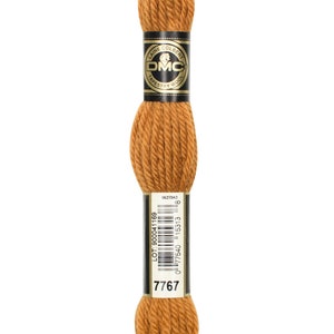 May include: A skein of DMC Tapestry Wool yarn in a warm, golden-brown shade, marked with the number 7767. The label features the DMC logo and product details. Suitable for a range of craft applications.