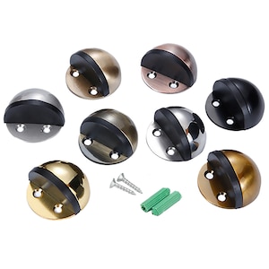 Könnte beinhalten: Satz mit acht Türstopper in verschiedenen Metallic-Oberflächen, darunter Gold, Silber, Bronze und Kupfer. Jeder Türstopper hat einen schwarzen Gummipuffer und zwei Schraubenlöcher. Das Set enthält außerdem zwei Schrauben und zwei Kunststoffdübel.
