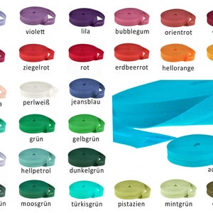 Könnte beinhalten: Eine Sammlung von 20 Rollen elastisches Band in verschiedenen Farben, darunter Lila, Rot, Orange, Rosa, Blau, Grün und Braun. Das Band ist in Reihen angeordnet und mit dem deutschen Farbnamen beschriftet.