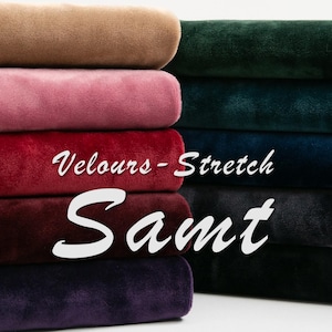 Könnte beinhalten: Ein Stapel farbiger Veloursstoffrollen in den Farbtönen Braun, Rosa, Rot, Burgunder und Lila. Der Text "Velours - Stretch Samt" ist in Weiß über dem Bild dargestellt.