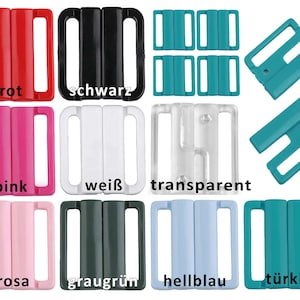 Könnte beinhalten: Sortiment von 10 BH-Verschlüssen aus Kunststoff in verschiedenen Farben, darunter Rot, Schwarz, Pink, Weiß, Transparent, Rosa, Graugrün, Hellblau und Türkis. Die Verschlüsse sind zum Einstellen der Passform von BHs gedacht.
