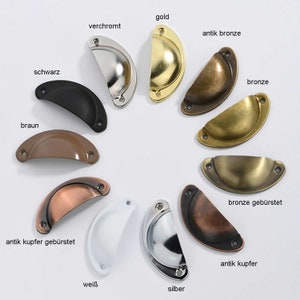 Könnte beinhalten: Sortiment von zehn Schrankknöpfen in verschiedenen Ausführungen, darunter Gold, Bronze, Schwarz, Weiß, Silber und Kupfer. Die Knöpfe haben alle die gleiche Form, einen Halbkreis mit einer leichten Krümmung.