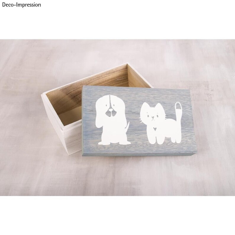 Puede incluir: Una caja de madera gris con un dise&ntilde;o de perro y gato blancos en la tapa. La caja est&aacute; abierta y el interior es visible.