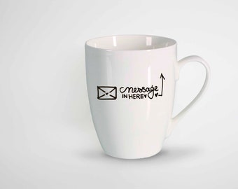May include: A white ceramic mug with a black graphic of an envelope and the words "message in here" with an arrow pointing upwards. The mug has a curved handle and a glossy finish.
