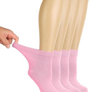 May include: A set of four light pink ankle socks featuring a ribbed cuff design. The socks are shown in a row, with one sock being pulled slightly to demonstrate the stretch and texture of the fabric. The material appears soft and knit.