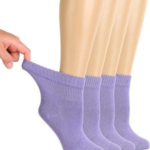 May include: A set of four ankle-length socks in a solid light purple color. Each sock features a ribbed cuff at the top and a smooth knit texture throughout the body, designed to sit just above the ankle bone for a standard fit and coverage.