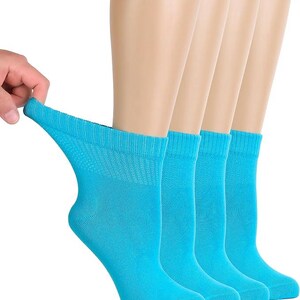 May include: A set of four bright turquoise ankle socks featuring a ribbed cuff design. The fabric is shown being stretched to demonstrate elasticity, highlighting the solid color and the knit texture of the material throughout the garment.