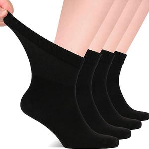 May include: A set of four solid black ankle socks featuring a ribbed cuff design. The socks are shown in a stacked arrangement, with the front-most sock being pulled slightly to demonstrate the stretch and texture of the fabric material.