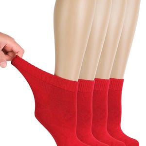 May include: A set of four solid red ankle socks featuring a ribbed cuff design. The socks are displayed on mannequin feet, with one sock being pulled slightly to show the stretch and texture of the fabric. The material is a consistent bright red.