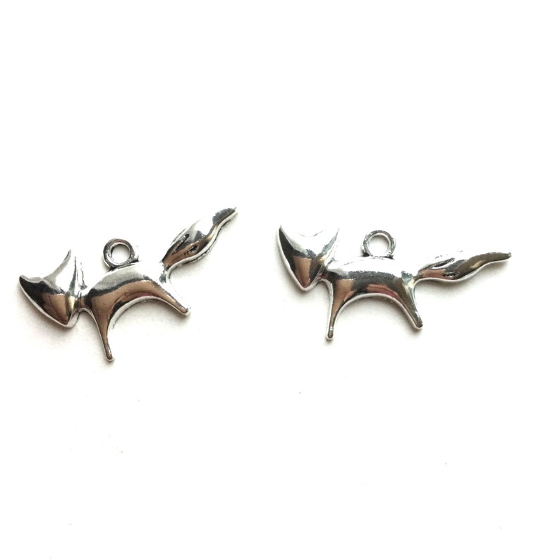 May include: Two silver fox charms with a loop for attaching to a necklace or bracelet.
