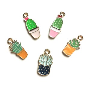 Pode incluir: Cinco pingentes de metal dourado com diferentes suculentas e cactos em vasos. Os pingentes s&atilde;o pintados em v&aacute;rias cores, incluindo verde, rosa, laranja, azul e preto.