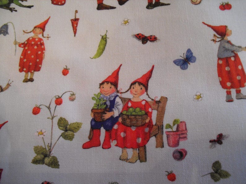 May include: White fabric with a whimsical garden scene. Features illustrations of gnomes, strawberries, butterflies, ladybugs, and other garden elements. Gnomes wear red hats and dresses with white polka dots. A charming, playful design.