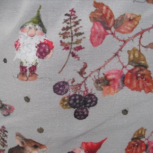 Könnte beinhalten: Ein Stoff mit einem skurrilen Muster mit einem Zwerg, der Beeren hält, zusammen mit Illustrationen von Brombeeren, Blättern und einem Schmetterling. Die Farbpalette umfasst Grautöne, Rot, Grün und Braun.