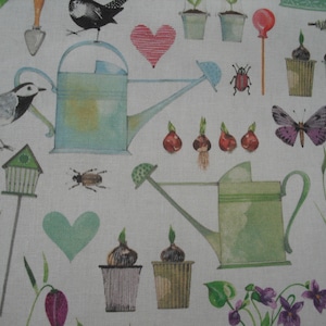 Op de afbeelding: Een witte stof met een aquarelontwerp met tuinelementen. Het ontwerp omvat gieters, vogels, vlinders, harten, insecten, vogelhuisjes en potplanten. Het kleurenpalet omvat tinten groen, blauw, paars en rood.