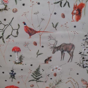 Könnte beinhalten: Ein hellgrauer Stoff mit einem sich wiederholenden Muster aus Waldtieren und Pflanzen. Das Design zeigt ein rotes Eichhörnchen, einen Fasan, einen Hirsch, eine Maus, Eulen und kleine Vögel, durchsetzt mit roten Pilzen, Tannenzapfen, Beeren und Farnen.