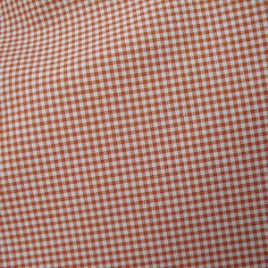 May include: Orange and white gingham fabric with a fine checkered pattern.