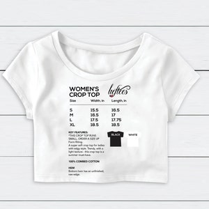 May include: White crop top with size chart and details about the fit and fabric. The chart shows sizes S, M, L, and XL with corresponding width and length measurements in inches. The text reads "Women's Crop Top", "Key Features: This crop top runs small, order a size up", "Form fitting", "A super soft crop top for ladies with edgy style. Trendy, with a light texture - this crop top is a summer must-have.", "100% Combed Cotton", "Hem: Bottom hem has an unfinished, raw edge."