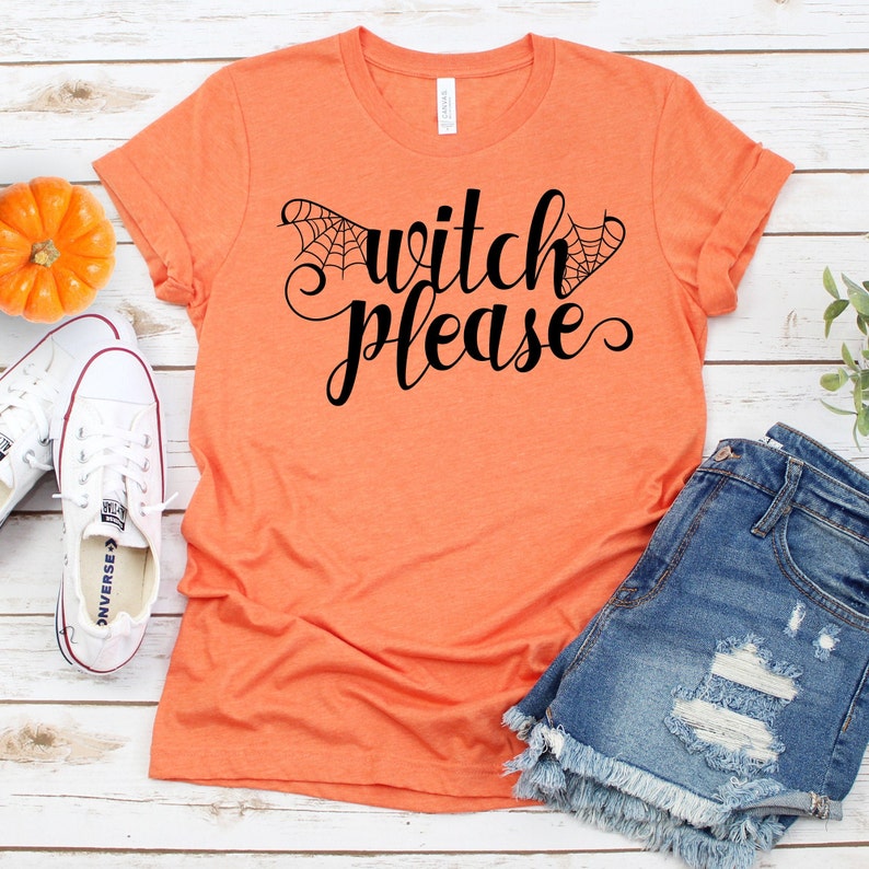 May include: Orange t-shirt with the text "witch please" in black script with a spiderweb design on either side of the word "witch".