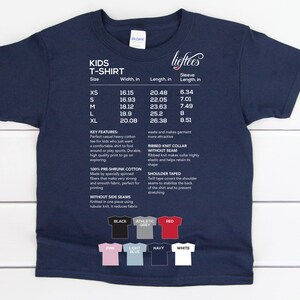 May include: A navy blue kids' t-shirt with a size chart and color options. The chart shows sizes XS to XL with corresponding width, length, and sleeve length measurements in inches. The color options include black, athletic grey, red, pink, light blue, navy, and white.