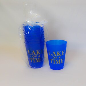 May include: A stack of blue plastic cups with gold lettering that reads "Lake of a Time" and a single blue plastic cup with the same lettering.