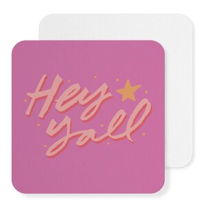 May include: Pink square coaster with the text "Hey y'all" in a pink and orange font with a gold star above the text.