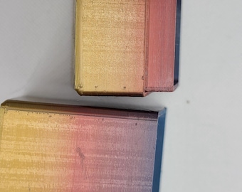 May include: Two 3D printed boxes with a gradient colour scheme. The boxes are a light gold colour at the top and fade to a dark red at the bottom. The boxes are made of a smooth, textured plastic.