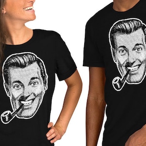 May include: Two people wearing black t-shirts with a white image of a man with a pipe. The man is smiling and has a mustache.