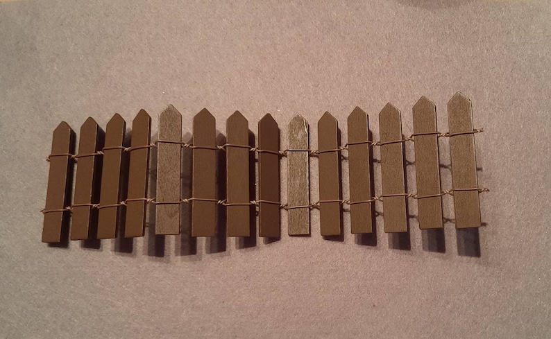 May include: A brown wooden picket fence with wire strung between the pickets.