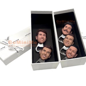 May include: A set of four bottle openers with personalized faces. The bottle openers are in a white box with the text "GoMiniMe" printed on the side.