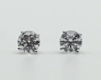 May include: A pair of silver stud earrings with clear round cubic zirconia stones.