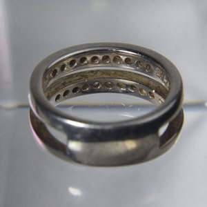 May include: A silver ring with two bands, each with a row of small round stones.