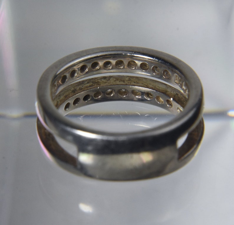 May include: A silver ring with two bands, each with a row of small round stones.
