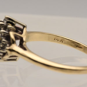 May include: A gold ring with a cluster of small diamonds set in the center. The ring is marked with the number "4-N".