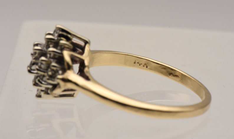 May include: A gold ring with a cluster of small diamonds set in the center. The ring is marked with the number "4-N".
