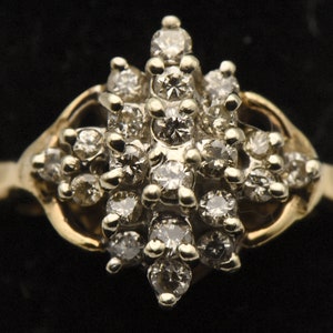May include: A gold ring with a cluster of small diamonds set in a starburst pattern.