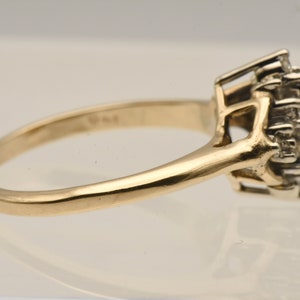 May include: A gold band ring with a cluster of small diamonds set in a prong setting.