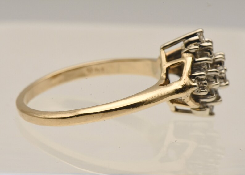 May include: A gold band ring with a cluster of small diamonds set in a prong setting.