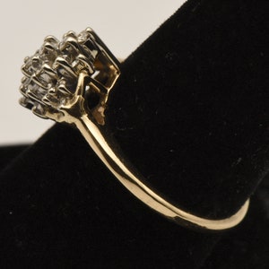 May include: A gold ring with a cluster of small diamonds set in a square shape.