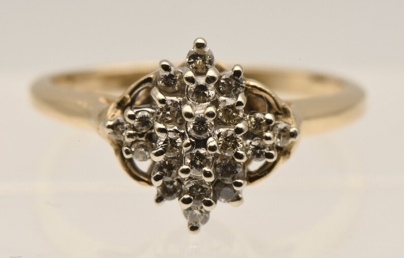 May include: A gold ring with a cluster of small diamonds set in a delicate, intricate design.
