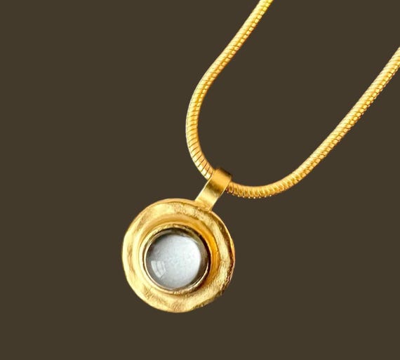 Ebb and Flow Necklace Baltic Gold Grey - Snake chain 22K matt gold plated with round pendant with grey glass stone and silver leaf