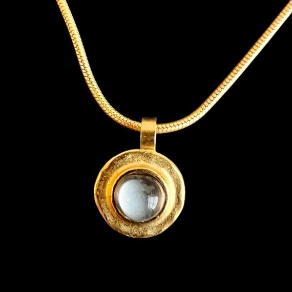 Ebbe und Flut Halskette Ostseegold grau - Schlangenkette 22 K matt vergoldet mit rundem Anhänger mit grauem Glasstein mit Blattsilber