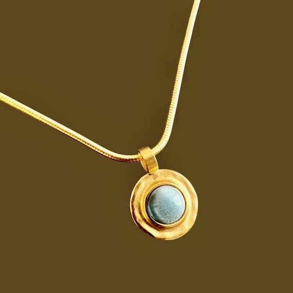 Ebb and Flow Necklace Baltic Gold Blue - Snake chain 22K matt gold plated with round pendant with blue glass stone and silver leaf