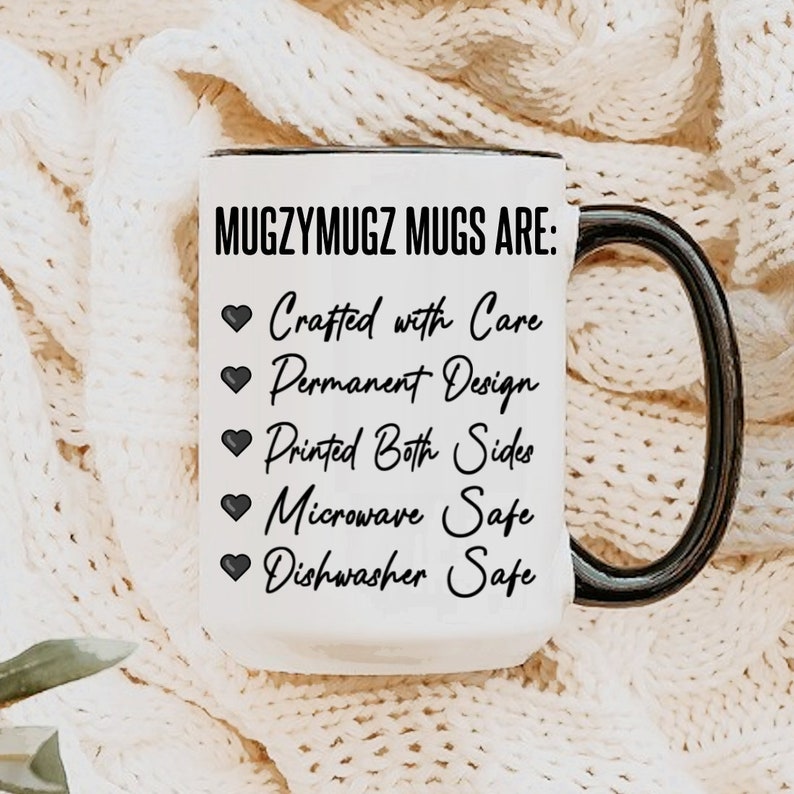 May include: A white ceramic mug with a black handle and rim, featuring the text "MUGZYMUGZ MUGS ARE: Crafted with Care, Permanent Design, Printed Both Sides, Microwave Safe, Dishwasher Safe."