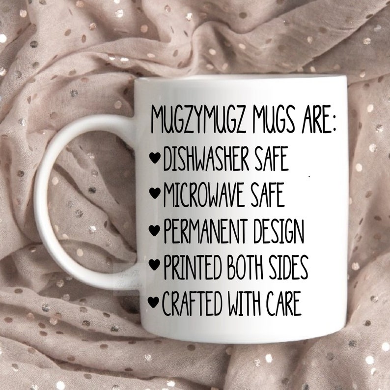 Peut inclure: Une tasse en c&eacute;ramique blanche avec une anse incurv&eacute;e. La tasse pr&eacute;sente le texte "MugzyMugz Mugs Are: Dishwasher Safe, Microwave Safe, Permanent Design, Printed Both Sides, Crafted With Care" en noir.