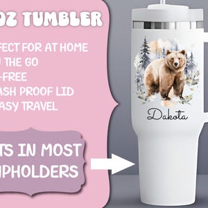 Pode incluir: Caneca branca de 1,18 litros com uma al&ccedil;a, apresentando uma ilustra&ccedil;&atilde;o em aquarela de um urso em uma cena de floresta. O nome "Dakota" est&aacute; escrito em script. A caneca tem uma tampa &agrave; prova de respingos e cabe na maioria dos porta-copos.