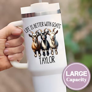 May include: White tumbler with a handle, featuring a graphic of three goats and the text "LIFE IS BETTER WITH GOATS" and "TAYLOR". A purple circle indicates "LARGE Capacity".
