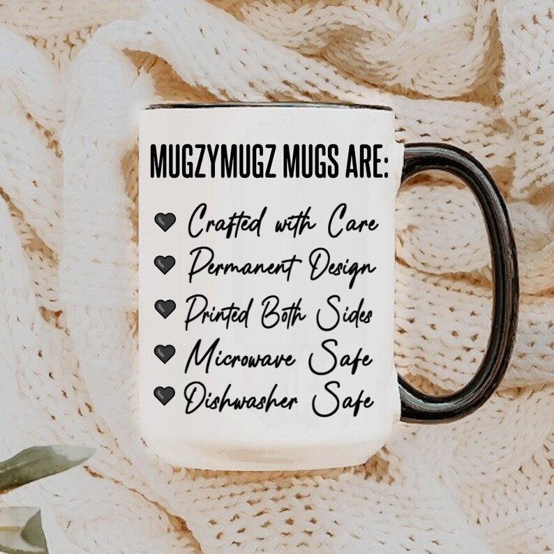 Pu&ograve; includere: Una tazza in ceramica bianca con manico e bordo neri. La tazza presenta il testo "MUGZYMUGZ MUGS ARE:" seguito da elenchi puntati con caratteristiche come "Crafted with Care" e "Dishwasher Safe". La tazza &egrave; posta su uno sfondo a maglia color crema.
