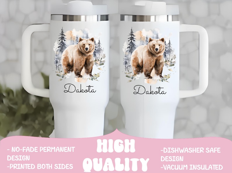 Pode incluir: Caneca de viagem branca com uma al&ccedil;a grande, com uma ilustra&ccedil;&atilde;o em aquarela de um urso pardo em uma cena de floresta. O nome "Dakota" est&aacute; escrito abaixo. A caneca tem tampa e al&ccedil;a brancas.