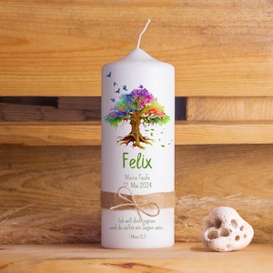Könnte beinhalten: Weiße Kerze mit einem bunten Baumdesign und dem Namen Felix, dem Datum 12. Mai 2024 und dem Text "Meine Taufe" (Meine Taufe). Die Kerze hat auch ein Band und den Text "Ich will dich segnen und du sollst ein Segen sein. 1 Mose 12.2" (Ich will dich segnen und du sollst ein Segen sein. 1. Mose 12.2).